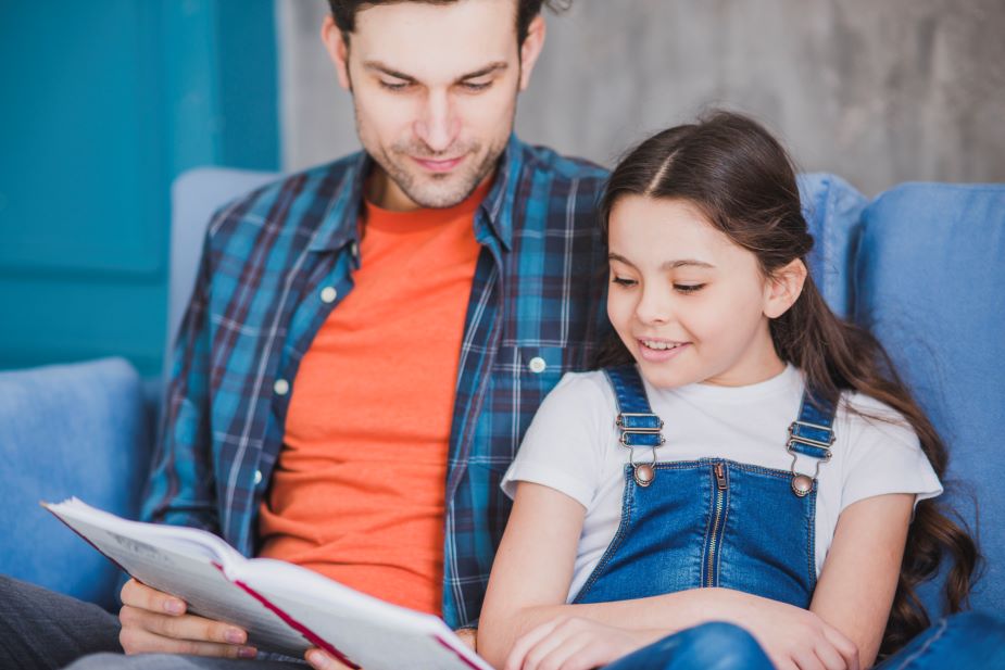 Papá leyendo a su hija, momento de calidad y fomento de la lectura.